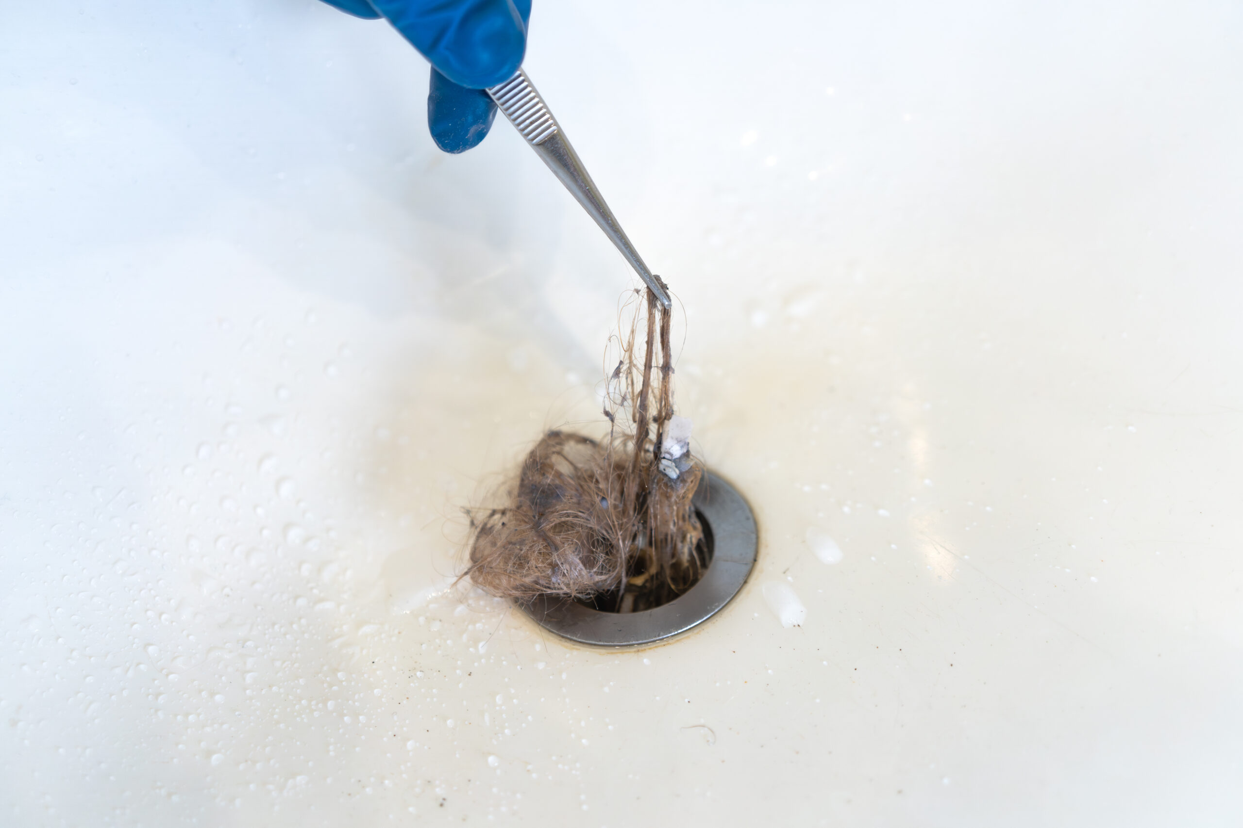 Clogged hair in the sink.Cleaning of the water drain system in the house.The problem of hair loss.A plumber's job.
