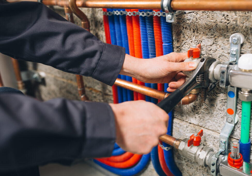 hands of plumber working in boiler room